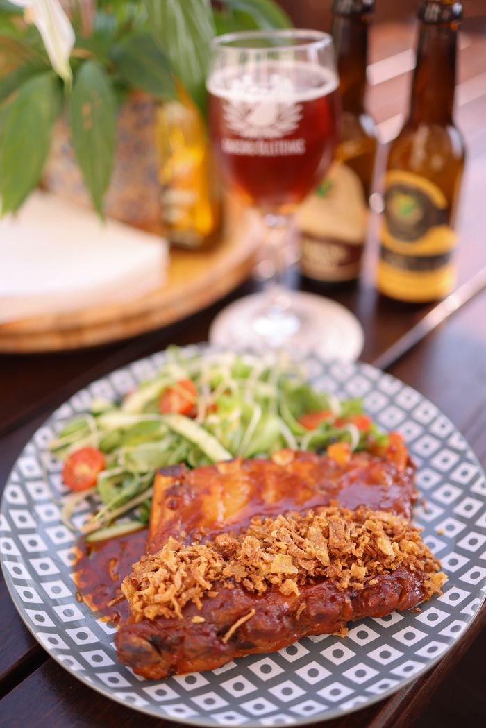 BBQ ribs served with a fresh salad and craft beer. Perfect for a cozy dinner at home.