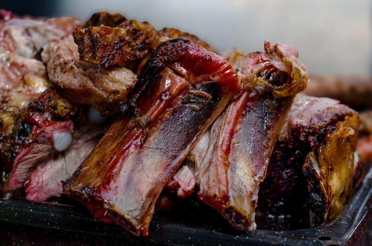 Close-up of delicious grilled ribs showcasing juicy and tender texture, typical from Argentina's barbecue style.