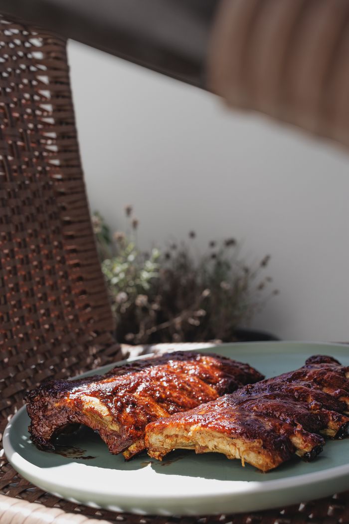 Juicy, glazed barbecue ribs served outdoors on a sunny day, perfect for a summer meal.